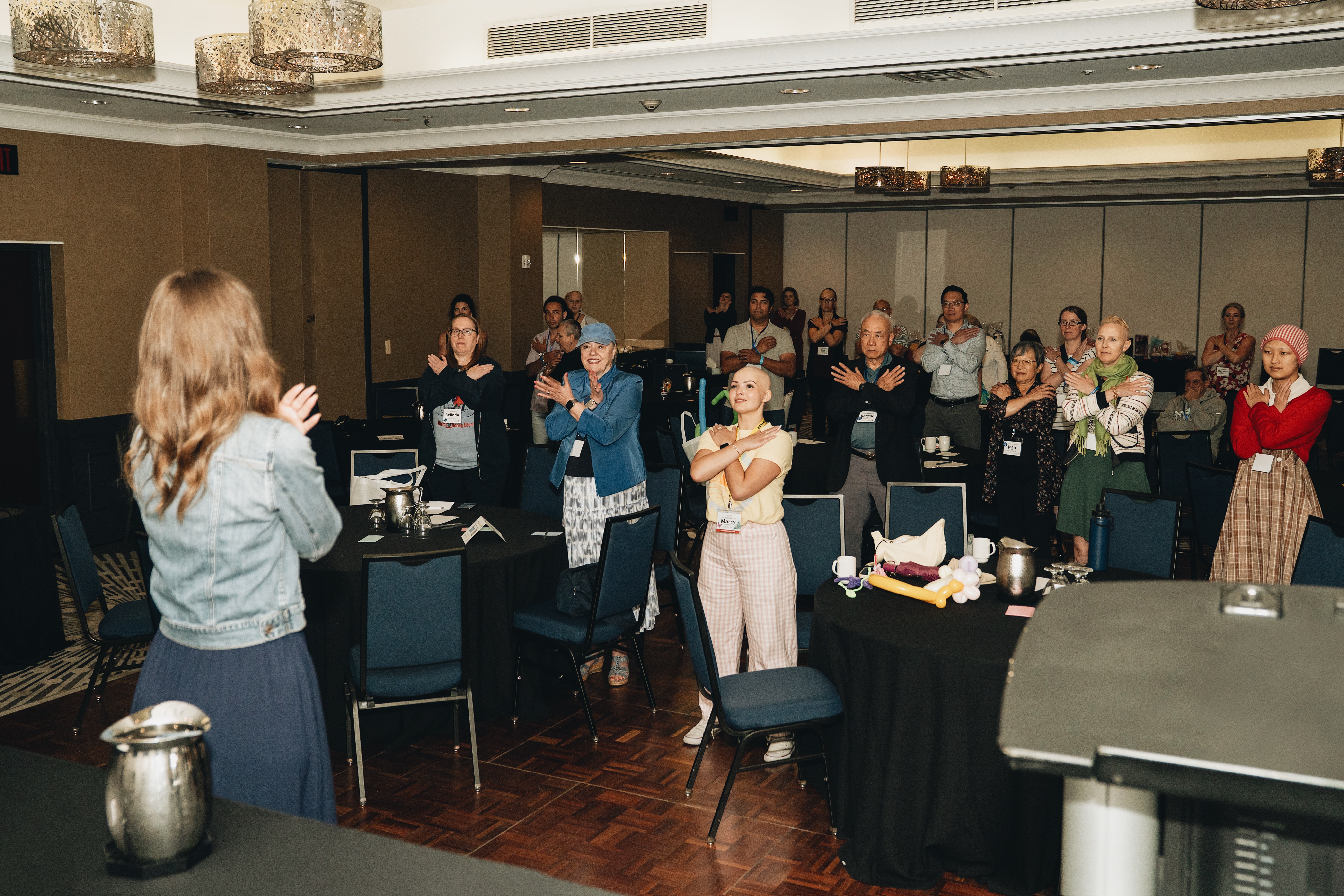 A full room of attendees following along with a live EFT tapping demonstration