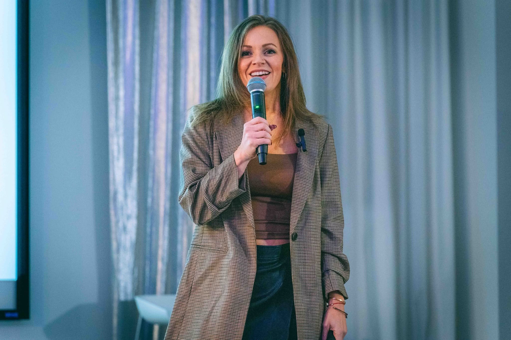 Cynthia speaking with a microphone at a conference